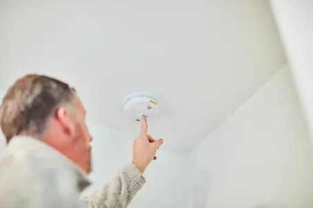 man checking a carbon monoxide alarm