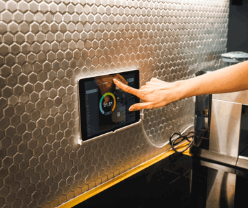 A hand adjusts a smart home tablet