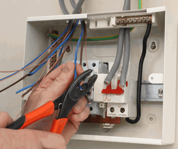 A hand with pliers works on wiring
